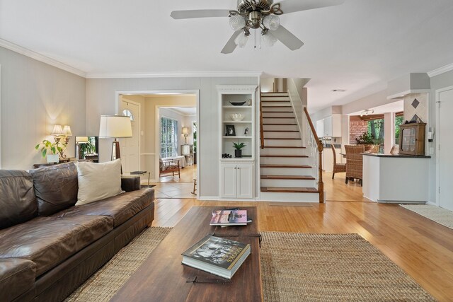 2828 S Logrun Cir, The Woodlands, TX 77380 - living room featuring ornamental molding, healthy amount of natural light, stairs, light wood-style flooring, and ceiling fan