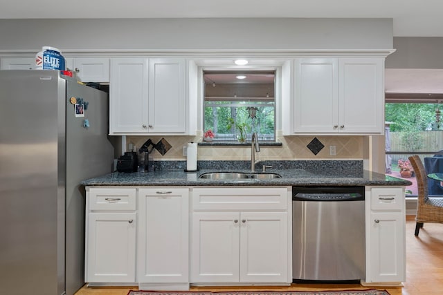 2828 S Logrun Cir, The Woodlands, TX 77380 - kitchen featuring appliances with stainless steel finishes, a sink, backsplash, and white cabinetry