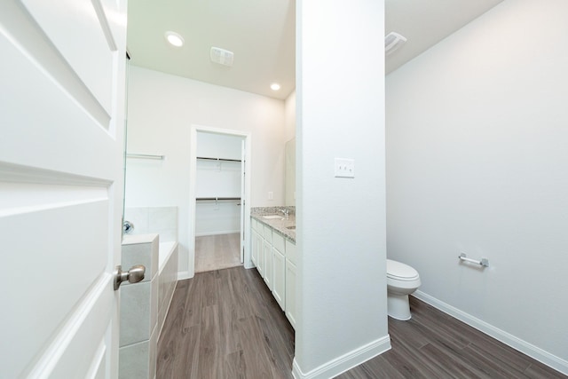 13228 Musky Dr, Conroe, TX 77384 - full bathroom with wood finished floors, a bath, vanity, and a spacious closet