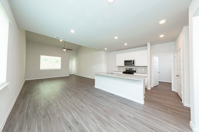 13228 Musky Dr, Conroe, TX 77384 - kitchen featuring stainless steel appliances, white cabinets, light wood-type flooring, ceiling fan, and recessed lighting