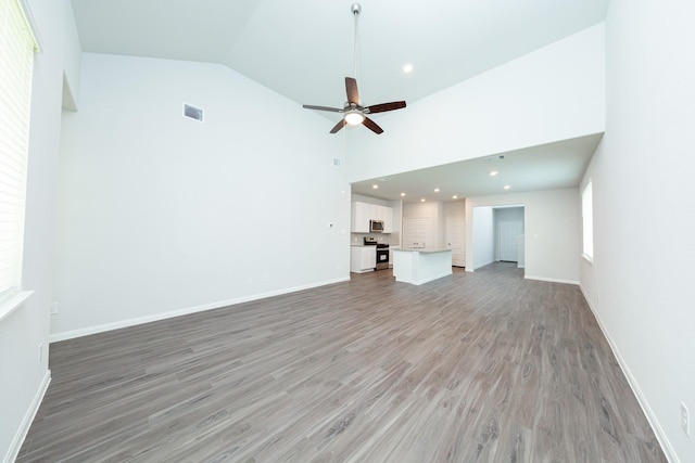 13228 Musky Dr, Conroe, TX 77384 - unfurnished living room with a ceiling fan, light wood finished floors, high vaulted ceiling, and recessed lighting