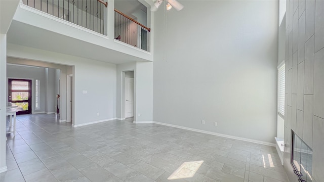 14227 Angelina Dr, Baytown, TX 77523 - unfurnished living room featuring a towering ceiling, a ceiling fan, baseboards, and light marble finish floors
