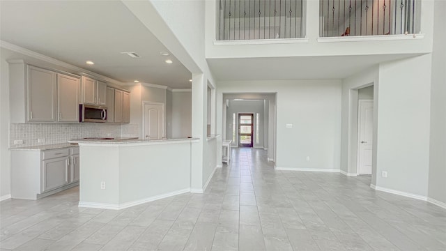 14227 Angelina Dr, Baytown, TX 77523 - kitchen featuring stainless steel microwave, recessed lighting, gray cabinetry, tasteful backsplash, and baseboards