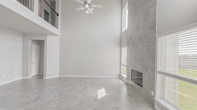 14227 Angelina Dr, Baytown, TX 77523 - unfurnished living room featuring a towering ceiling, a ceiling fan, a high end fireplace, and baseboards