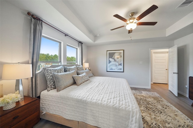 11608 Whirlaway Dr, Willis, TX 77318 - bedroom with a tray ceiling, wood finished floors, baseboards, and ceiling fan