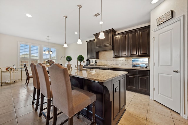 19823 Sonterra Ln, Richmond, TX 77407 - kitchen with backsplash, a breakfast bar area, light tile patterned floors, light stone counters, and recessed lighting