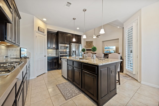 19823 Sonterra Ln, Richmond, TX 77407 - kitchen featuring stainless steel appliances, a sink, a breakfast bar area, backsplash, and light tile patterned flooring