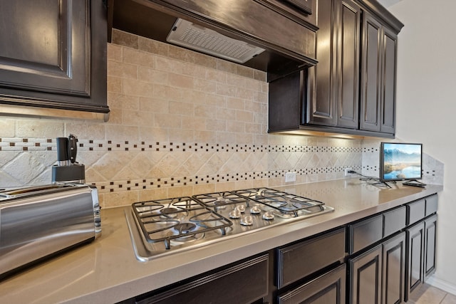 19823 Sonterra Ln, Richmond, TX 77407 - kitchen featuring stainless steel gas cooktop, light countertops, ventilation hood, and backsplash