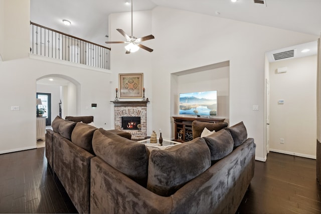 19823 Sonterra Ln, Richmond, TX 77407 - living area featuring arched walkways, a ceiling fan, dark wood-type flooring, a fireplace, and baseboards