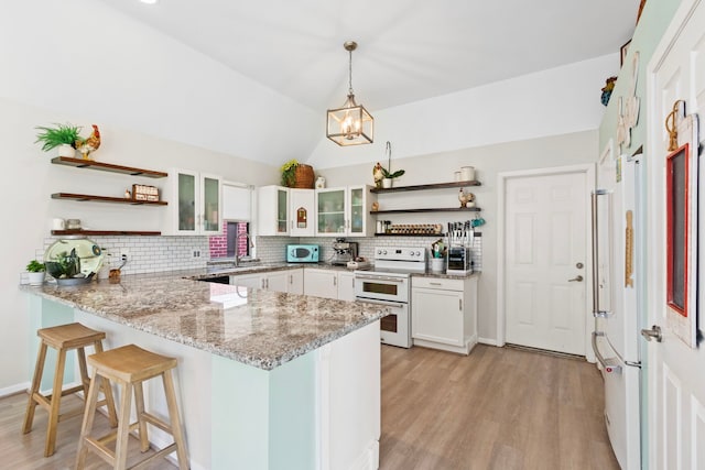 17322 Camberwell Green Ln, Houston, TX 77070 - kitchen with open shelves, white appliances, a peninsula, light wood-style flooring, and lofted ceiling