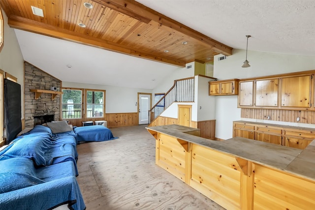 245 Bridgewater, Onalaska, TX 77360 - living room featuring a wainscoted wall, stairway, a stone fireplace, and wood walls