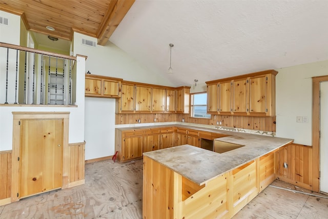 245 Bridgewater, Onalaska, TX 77360 - kitchen with a peninsula, a wainscoted wall, wood walls, and light countertops