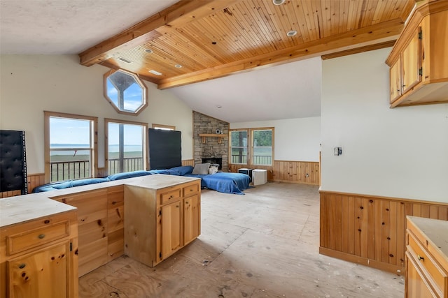 245 Bridgewater, Onalaska, TX 77360 - kitchen featuring wainscoting, wooden walls, open floor plan, a fireplace, and light countertops