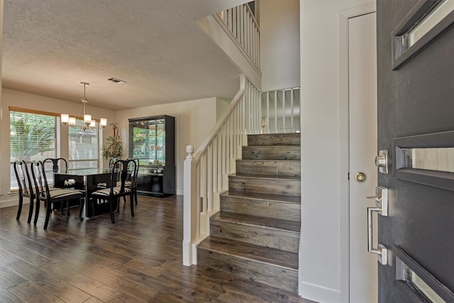 52 S Havenridge Dr, The Woodlands, TX 77381 - foyer entrance featuring a chandelier, stairway, dark wood finished floors, a textured ceiling, and baseboards