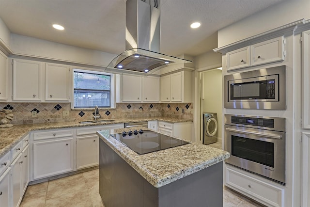 52 S Havenridge Dr, The Woodlands, TX 77381 - kitchen with appliances with stainless steel finishes, washer / dryer, island range hood, a sink, and tasteful backsplash