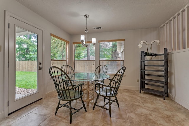 52 S Havenridge Dr, The Woodlands, TX 77381 - dining space with healthy amount of natural light, a chandelier, baseboards, and a textured ceiling