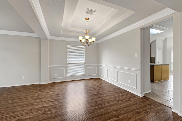 9927 Barr Lake Dr, Houston, TX 77095 - empty room with a raised ceiling, a chandelier, dark wood-type flooring, a wainscoted wall, and ornamental molding