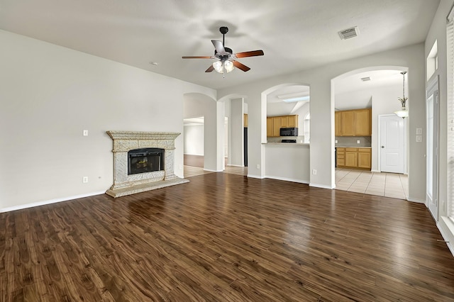 9927 Barr Lake Dr, Houston, TX 77095 - unfurnished living room with ceiling fan, wood finished floors, a fireplace with raised hearth, and baseboards