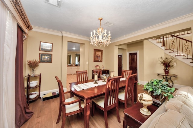 10138 Bayou Manor Ln, Houston, TX 77064 - dining room featuring a chandelier, wood finished floors, stairs, crown molding, and baseboards