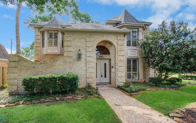 5810 Springton Ln, Spring, TX 77379 - view of front facade featuring brick siding, a front yard, and a shingled roof