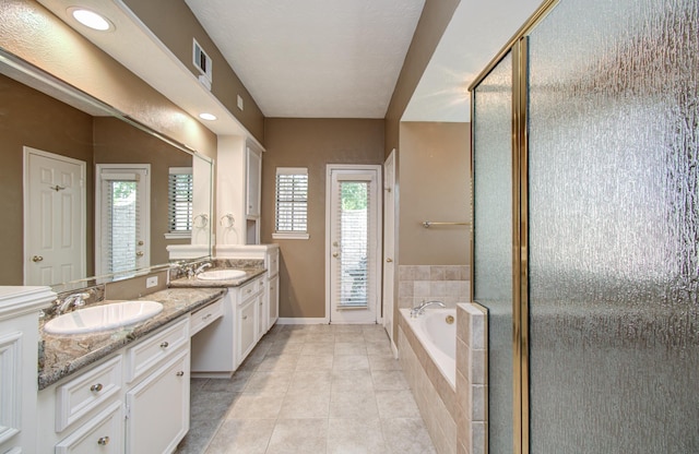 5810 Springton Ln, Spring, TX 77379 - full bathroom with double vanity, a bath, tile patterned floors, a shower stall, and baseboards