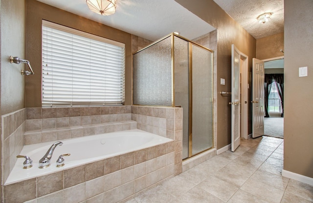 5810 Springton Ln, Spring, TX 77379 - full bathroom featuring a garden tub, a stall shower, tile patterned flooring, and baseboards