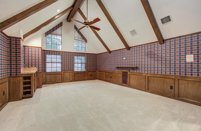 5810 Springton Ln, Spring, TX 77379 - unfurnished living room featuring beam ceiling, wainscoting, light colored carpet, high vaulted ceiling, and wallpapered walls