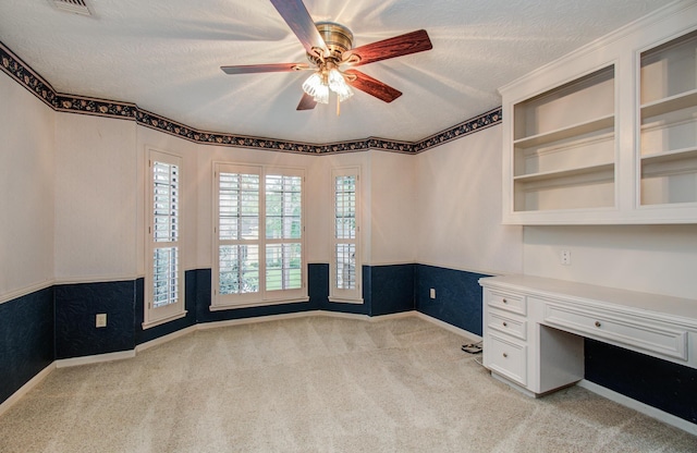 5810 Springton Ln, Spring, TX 77379 - unfurnished office with built in desk, ceiling fan, light carpet, a textured ceiling, and baseboards