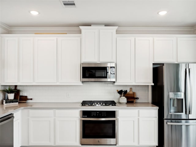2020 Groveland Glen Dr, Houston, TX 77051 - kitchen featuring stainless steel appliances, light countertops, white cabinetry, decorative backsplash, and crown molding