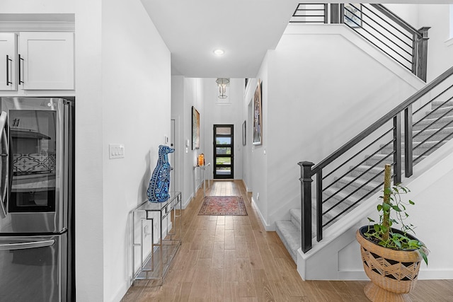 4818 Nodding Thistle Trl, Fulshear, TX 77441 - hallway with light wood-style flooring, stairs, baseboards, and recessed lighting