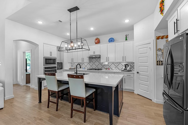 4818 Nodding Thistle Trl, Fulshear, TX 77441 - kitchen with appliances with stainless steel finishes, backsplash, light countertops, a center island with sink, and a breakfast bar area