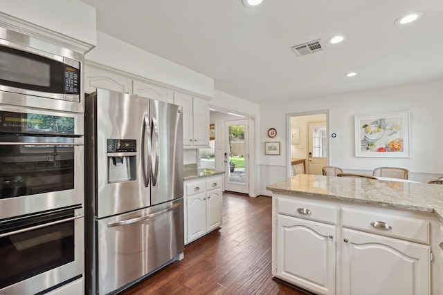 8019 Skyline Dr, Houston, TX 77063 - kitchen featuring stainless steel appliances, dark wood-type flooring, light stone countertops, white cabinetry, and recessed lighting