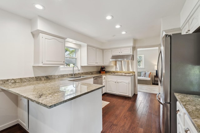 8019 Skyline Dr, Houston, TX 77063 - kitchen featuring freestanding refrigerator, a sink, a peninsula, under cabinet range hood, and light stone countertops