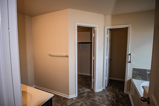 17907 Acorn Field Trl, Humble, TX 77346 - bathroom with vanity, a tub to relax in, a walk in closet, and baseboards