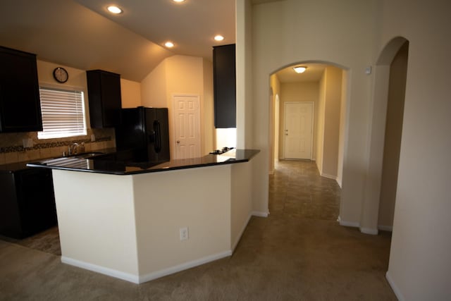 17907 Acorn Field Trl, Humble, TX 77346 - kitchen featuring black refrigerator with ice dispenser, arched walkways, dark countertops, decorative backsplash, and light carpet