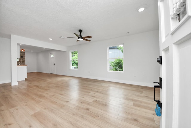 501 Schilling St, Baytown, TX 77520 - unfurnished living room with ceiling fan, light wood-style flooring, recessed lighting, baseboards, and a textured ceiling