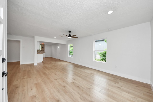 501 Schilling St, Baytown, TX 77520 - unfurnished living room featuring a ceiling fan, a textured ceiling, light wood-style floors, baseboards, and recessed lighting