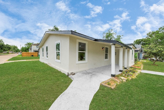 501 Schilling St, Baytown, TX 77520 - view of side of property featuring a yard, stucco siding, and a patio area