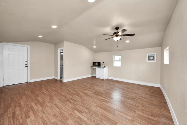 501 Schilling St, Baytown, TX 77520 - unfurnished living room with vaulted ceiling, light wood-style floors, ceiling fan, baseboards, and recessed lighting