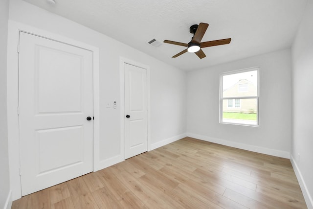 501 Schilling St, Baytown, TX 77520 - unfurnished bedroom featuring light wood finished floors, baseboards, and a ceiling fan
