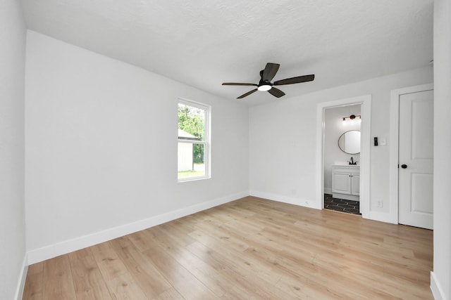 501 Schilling St, Baytown, TX 77520 - unfurnished bedroom with light wood-style flooring, baseboards, a sink, and ensuite bath
