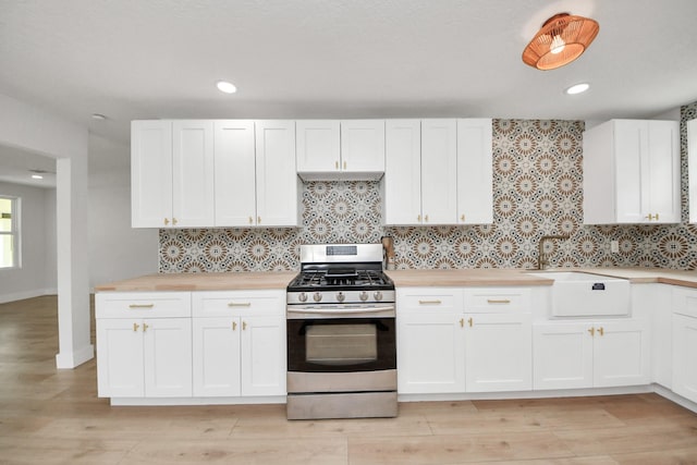 501 Schilling St, Baytown, TX 77520 - kitchen with stainless steel range with gas cooktop, wood counters, a sink, tasteful backsplash, and recessed lighting