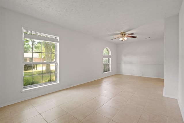 12839 Aste Ln, Houston, TX 77065 - unfurnished room with ceiling fan, a textured ceiling, baseboards, and light tile patterned flooring