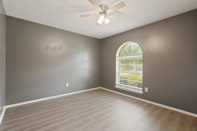 12839 Aste Ln, Houston, TX 77065 - unfurnished room with wood finished floors, a textured ceiling, ceiling fan, and baseboards