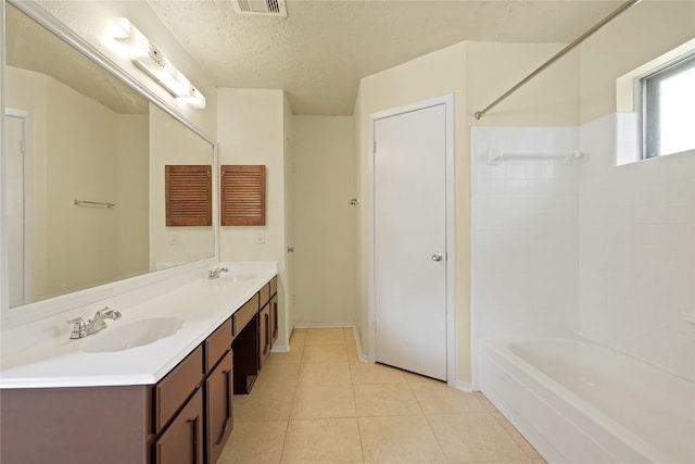 12839 Aste Ln, Houston, TX 77065 - full bath featuring double vanity, bathtub / shower combination, tile patterned floors, a textured ceiling, and baseboards