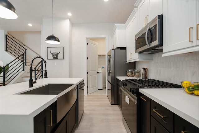 2522 Live Oak St, Houston, TX 77004 - kitchen featuring appliances with stainless steel finishes, white cabinets, light wood-style flooring, light countertops, and tasteful backsplash