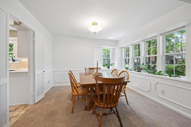 2055 Pine River Dr, Houston, TX 77339 - dining area featuring light colored carpet, a decorative wall, and wainscoting