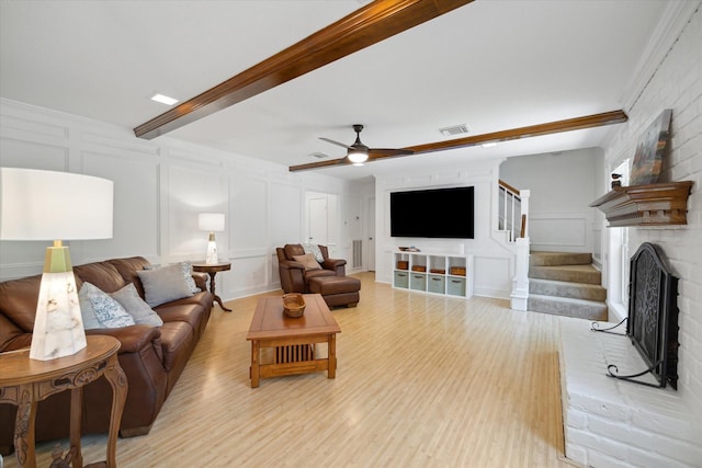 2055 Pine River Dr, Houston, TX 77339 - living area with a decorative wall, light wood finished floors, ceiling fan, stairs, and a brick fireplace