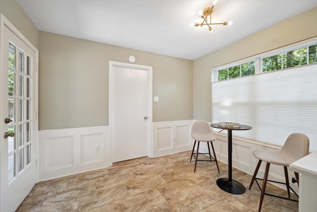 2055 Pine River Dr, Houston, TX 77339 - dining room with a decorative wall, wainscoting, a chandelier, and stone finish flooring
