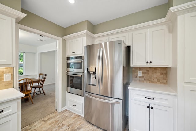 2055 Pine River Dr, Houston, TX 77339 - kitchen featuring stainless steel appliances, light countertops, white cabinetry, and tasteful backsplash